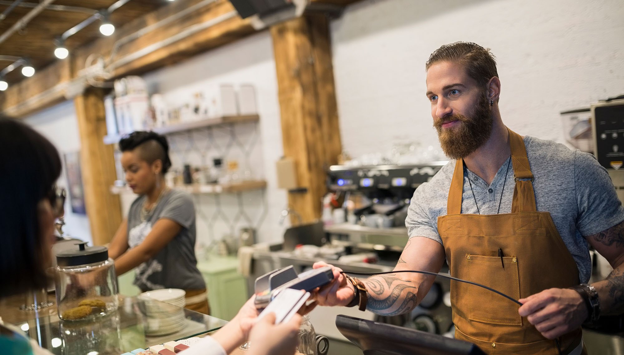 person paying instore with smiling employee