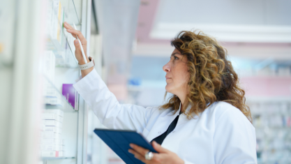 Pharmacien utilisant une tablette numérique pour faire l’inventaire dans une pharmacie